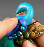 Beads being added to the clay peacock